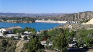 uma vista para um lago com uma casa numa colina em Cabañas Negratín em Cuevas del Campo