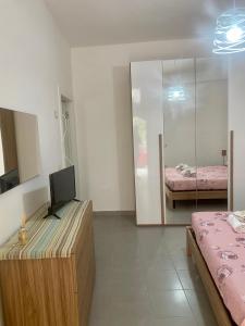 Zimmer mit einem Schreibtisch, einem TV und einem Bett in der Unterkunft Piccolo fiore B&B in Capaccio-Paestum