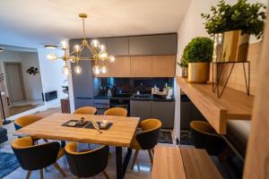 cocina y comedor con mesa de madera y sillas en Apartment Daria, en Vinjerac