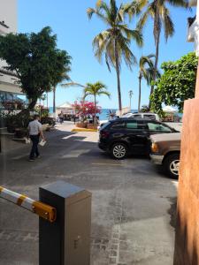 a man walking down a street next to a parking lot at Malecon uno PV Libertad 111 Centro 48300 Puerto Vallarta Jal in Puerto Vallarta