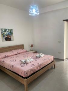 ein Schlafzimmer mit einem Bett mit einer rosa Decke in der Unterkunft Piccolo fiore B&B in Capaccio-Paestum