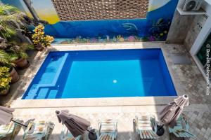 an overhead view of a swimming pool with two lawn chairs at Hotel Casa Pridda in Puerto Escondido