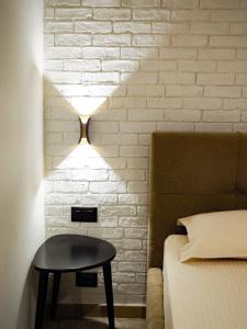 a bedroom with a bed and a table next to a brick wall at Rittson - Boutique Hotel in Vlorë