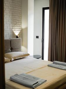 a bedroom with a bed with two towels on it at Rittson - Boutique Hotel in Vlorë