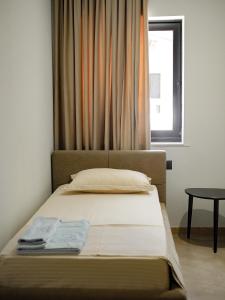 a bed sitting in a room with a window at Rittson - Boutique Hotel in Vlorë