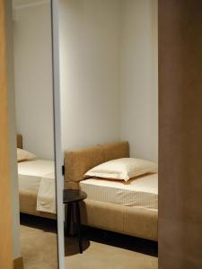 2 camas en una habitación pequeña con espejo en Rittson - Boutique Hotel en Vlorë