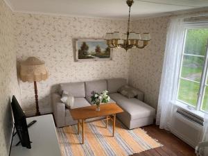 uma sala de estar com um sofá e uma mesa em Waterfront house with jacuzzi & jetty in Stockholm em Estocolmo