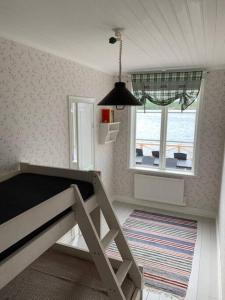 1 dormitorio con cama, ventana y alfombra en Waterfront house with jacuzzi & jetty in Stockholm en Estocolmo