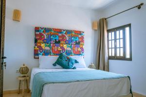 una camera con letto e testata colorata di villa Floratus a Essaouira Altre 27 foto
