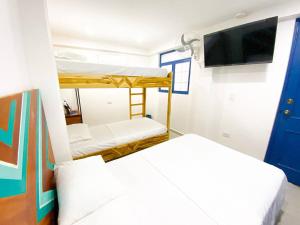 two bunk beds in a room with a flat screen tv at Casa Liz Hotel Boutique in Santa Marta