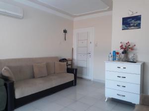 a living room with a couch and a white dresser at SARIMSAKLI PLAJINA 0 METRE DENİZ MANZARALI LÜX DAİRE in Ayvalık