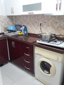 een keuken met een fornuis en een wasmachine bij SARIMSAKLI PLAJINA 0 METRE DENİZ MANZARALI LÜX DAİRE in Ayvalık