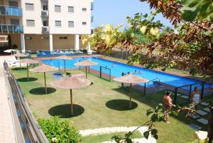 - une grande piscine avec des parasols dans l'établissement Norwegian Woods - Abedules, à El Campello