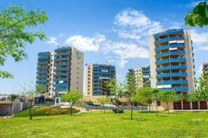 un parc devant de grands immeubles dans l'établissement Norwegian Woods - Abedules, à El Campello