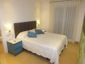 - une chambre avec un lit doté d'une table de chevet bleue et d'oreillers bleus dans l'établissement Norwegian Woods - Abedules, à El Campello