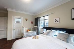 1 dormitorio con 1 cama blanca grande y 1 cuna en Centric big old house, roomy, petfriendly and renovated, en Lima