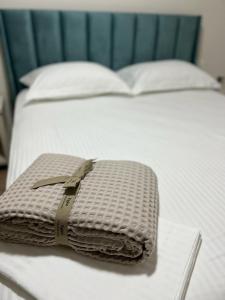 a purse sitting on top of a white bed at PineTrees Beach House with swimming pool in Golem +7 photos