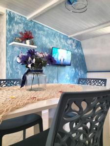 a dining room table with a vase of flowers on it at Sea Side Attic in Rosolina Mare