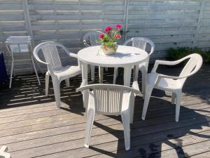 Biały stół i krzesła z wazonem kwiatów w obiekcie Mehri w mieście Uppsala