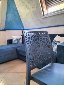 a chair sitting in a room with a couch at Sea Side Attic in Rosolina Mare