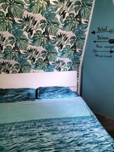 a bedroom with a bed with a floral wallpaper at Sea Side Attic in Rosolina Mare