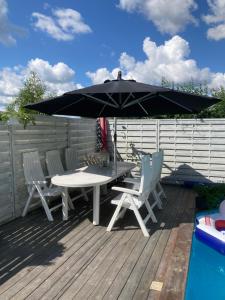 a table and chairs under an umbrella on a deck at Mehri in Uppsala