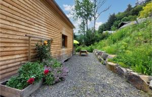 a garden next to a wooden building with flowers at Nice Home In Mont-dore With Wifi in Le Mont-Dore