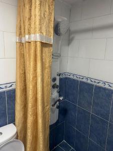 a bathroom with a shower with a yellow shower curtain at Al-Amer Chalets in Aqaba