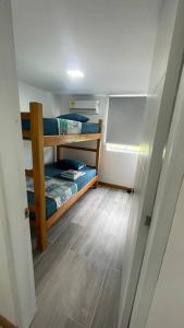 Kleines Zimmer mit 2 Etagenbetten und Holzboden in der Unterkunft Caribe Campestre coveñas in Coveñitas