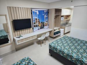 a hotel room with two beds and a flat screen tv at RESERVE SEU FLAT E GANHE SUA DIVERSÃO in Caldas Novas