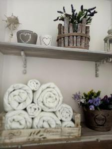 a shelf with towels and flowers on it at Grotta dei Puntali B&B in Carini