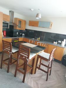 a kitchen with a wooden table and chairs in it at The Plaza Suites High St Bangor in Bangor