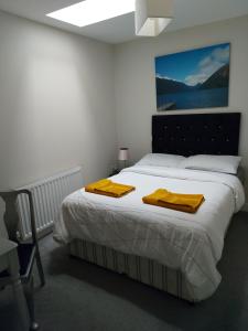 a bedroom with a bed with yellow towels on it at The Plaza Suites High St Bangor in Bangor