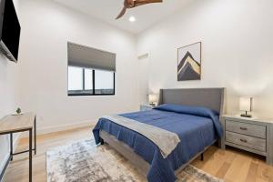 a bedroom with a blue bed and a window at central contemporary w/ POOL and SPA in Austin +36 photos
