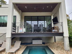 a house with a balcony and a swimming pool at central contemporary w/ POOL and SPA in Austin