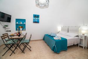 1 dormitorio con 1 cama, mesa y sillas en Casa GianAngel Ostuni en Ostuni