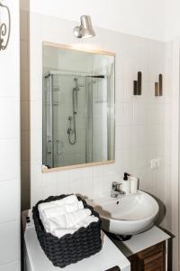 bagno bianco con lavandino e specchio di Casa R&R *10' a Piedi da Piazza Del Campo*! a Siena