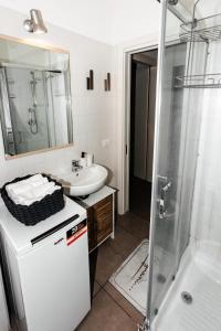 bagno bianco con lavandino e doccia di Casa R&R *10' a Piedi da Piazza Del Campo*! a Siena