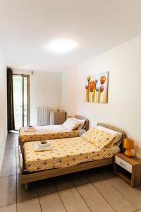 una camera con due letti e un dipinto sul muro di Casa R&R *10' a Piedi da Piazza Del Campo*! a Siena