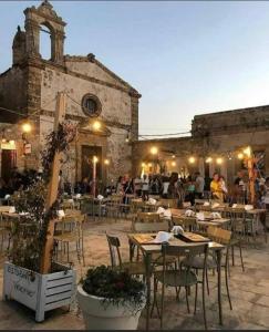 un restaurant avec des tables et des chaises et des personnes dans un bâtiment dans l'établissement Casa Vacanze Matilde Marzamemi, à Marzamemi