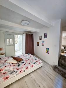 Un dormitorio con una cama grande con flores. en Le Willow, en Châteauneuf-du-Pape