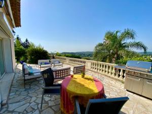 a patio with a table and chairs on a balcony at Villa - Chambre privée au calme pour 2 personnes in Vence