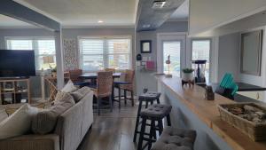 a living room with a couch and a bar with a table at Sea-La-Vie, your beach house oasis in Freeport