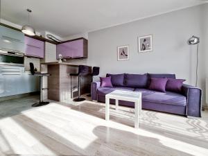 - un salon avec un canapé violet et une table dans l'établissement CLASSY APARTMENTS - AQUAPARK Reda, à Reda
