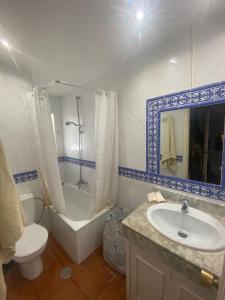 een badkamer met een bad, een toilet en een wastafel bij Casa adosada Huerta del Prado in Marbella