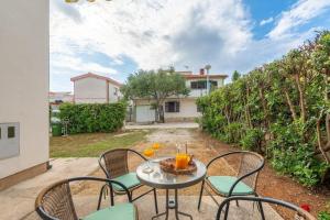 - une table avec des chaises et des boissons sur la terrasse dans l'établissement Studio Apartman Amelie, à Vir