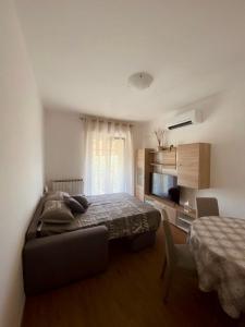 een slaapkamer met een bed, een tafel en een televisie bij IL DANDY appartamento con parcheggio in Trieste
