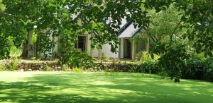 una casa con un césped verde delante de ella en The Croft Sri Lanka, 