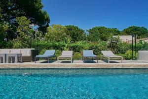 un grupo de sillas sentadas junto a una piscina en La Brisa-Villa 3ch- authentique-luxe-Saint-Tropez, en Saint-Tropez