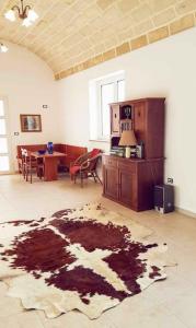 ein Wohnzimmer mit einem Tisch und einem Teppich auf dem Boden in der Unterkunft DOMUS BARONE in Spongano